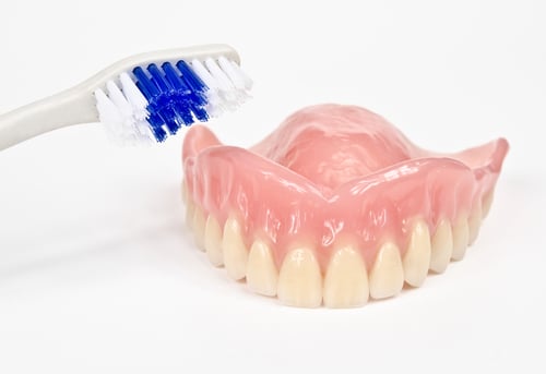 a denture and a toothbrush